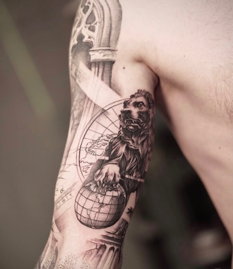 Fine line tattoo of a lion resting a paw on a globe
